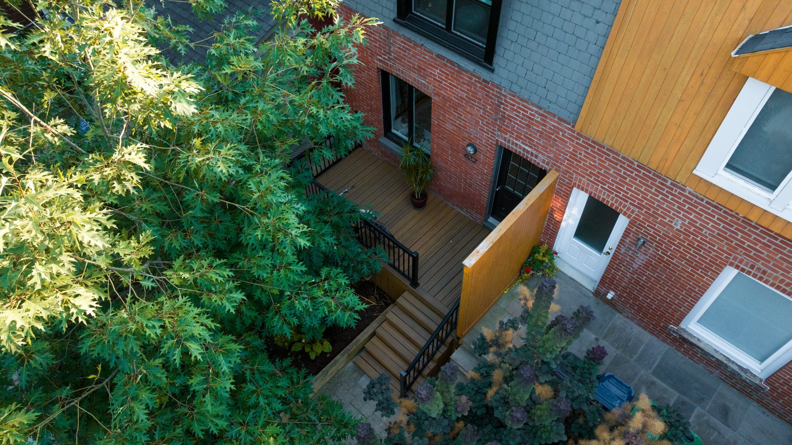Aerial view of deck, privacy screen, and stone patio