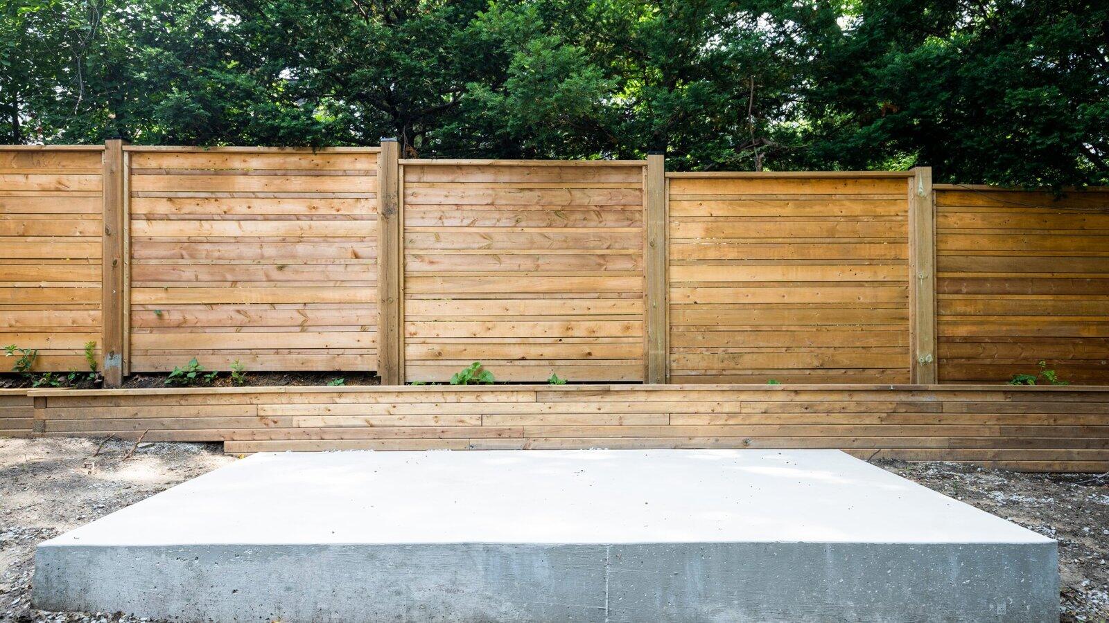 Concrete pad with fence and retaining wall in The Kingsway